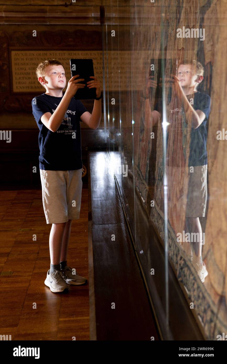 12/07/22  Michael, 11, uses an interactive augmented reality, digital tour on a tablet at St Mary’s Guildhall to explore The Coventry Tapestry dating Stock Photo