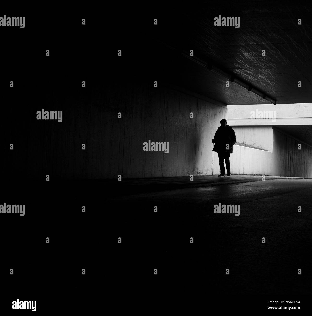 Monochrome image of elderly man in tunnel Stock Photo