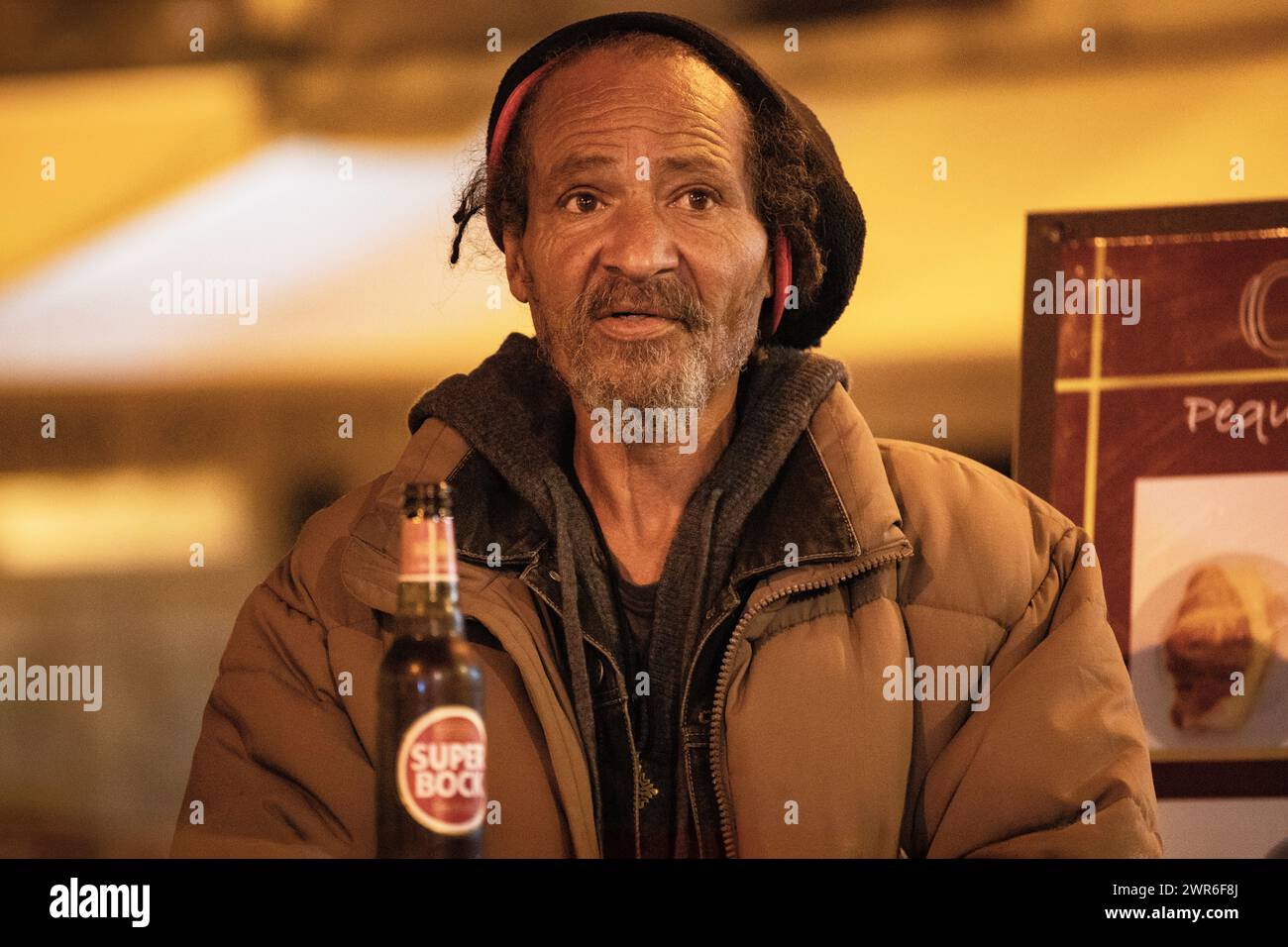 An elderly Rastafarian without a roof sits at the bar, exuding wisdom and resilience amidst adversity. Stock Photo