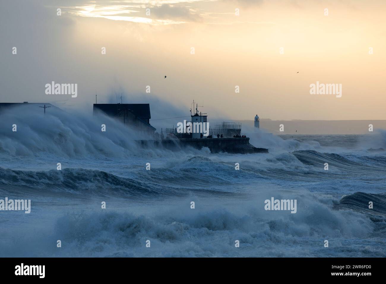 18/02/22   Photographers brave huge waves which crash over the 30ft-high lighthouse and harbour breakwater, in Porthcawl, South Wales as Storm Eunice Stock Photo