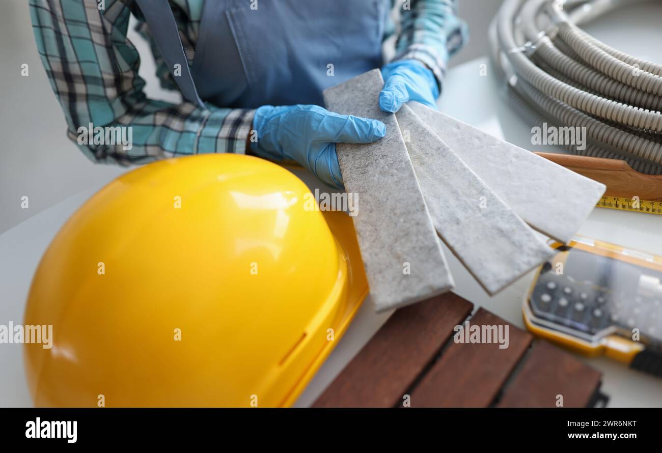 Builder holding gray tiles for bathroom in workshop closeup Stock Photo