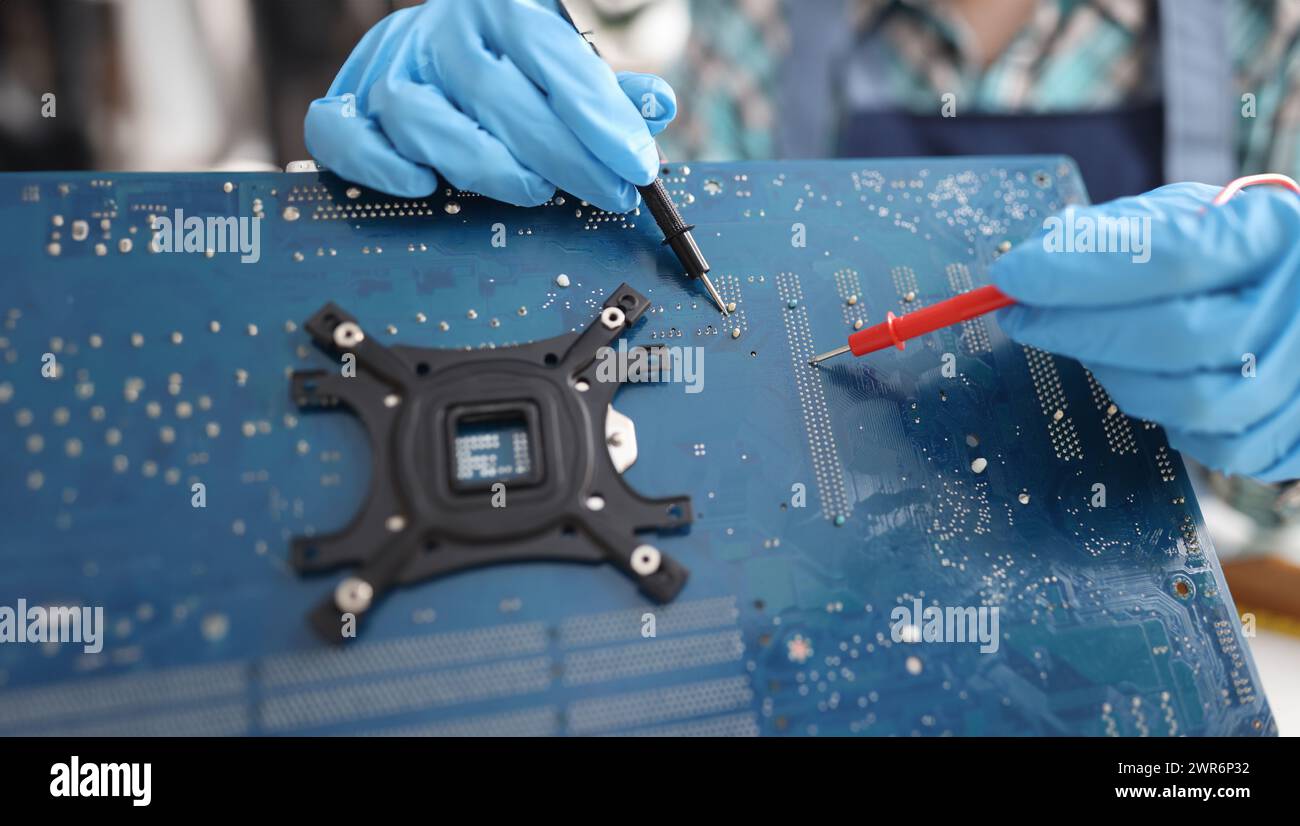 Repairman diagnosing breakdown in computer motherboard using tester