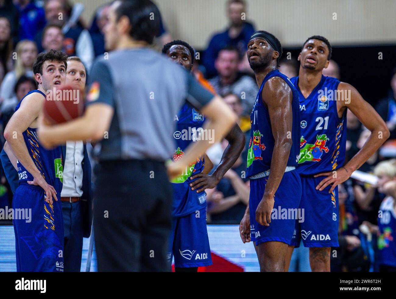 10 March 2024, Mecklenburg-Western Pomerania, Rostock: Basketball: Bundesliga, Rostock Seawolves - Alba Berlin, Main Round, Matchday 23, Stadthalle Rostock. The disappointed Rostock players Lester Medford (l), Derrick Alston Jr. (M) and Chevez Goodwin (r) after the end of the game. Photo: Jens Büttner/dpa Stock Photo