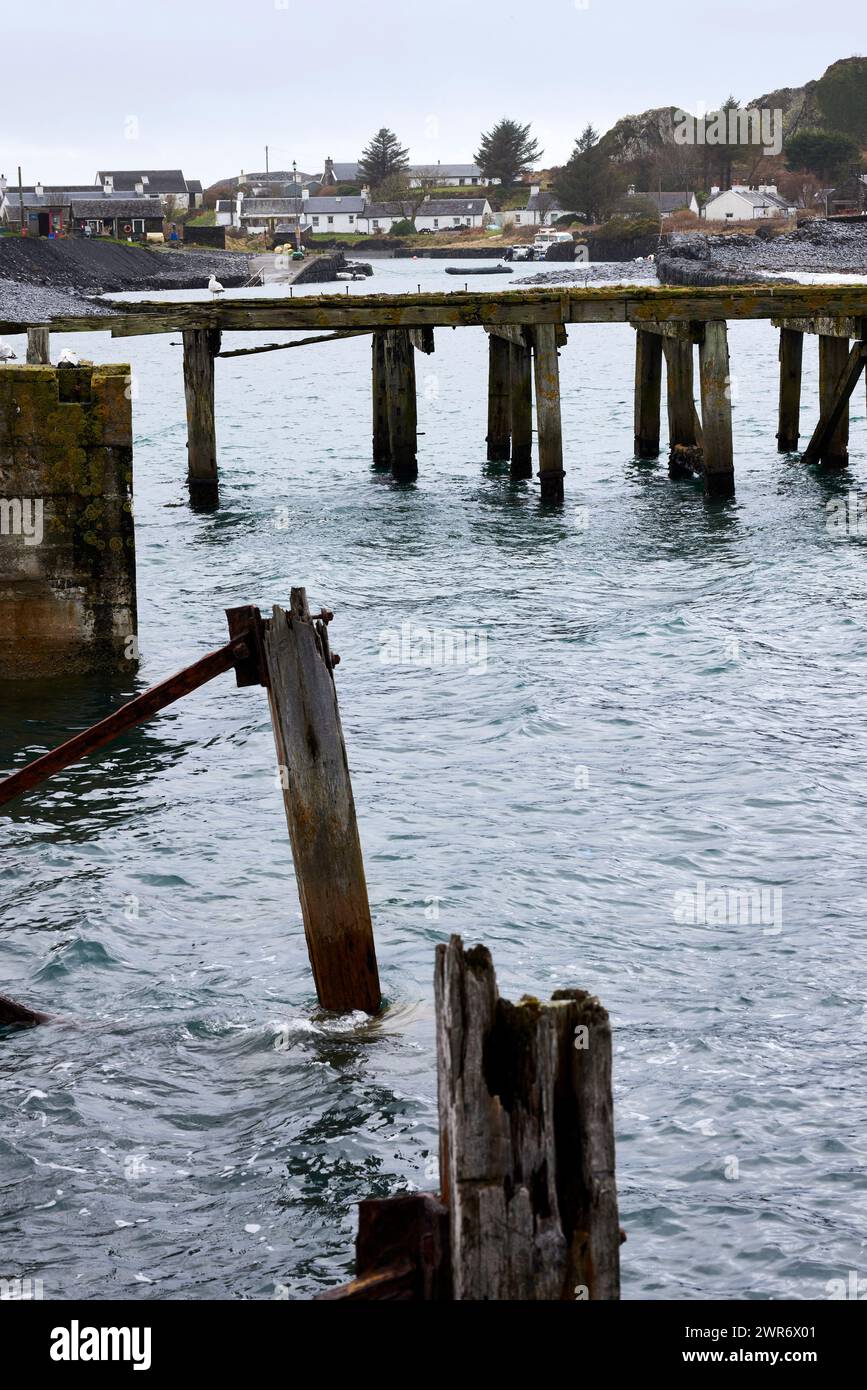 Across the Sound of Easdale, the derelict pier stands as testament to the past slate industry Stock Photo