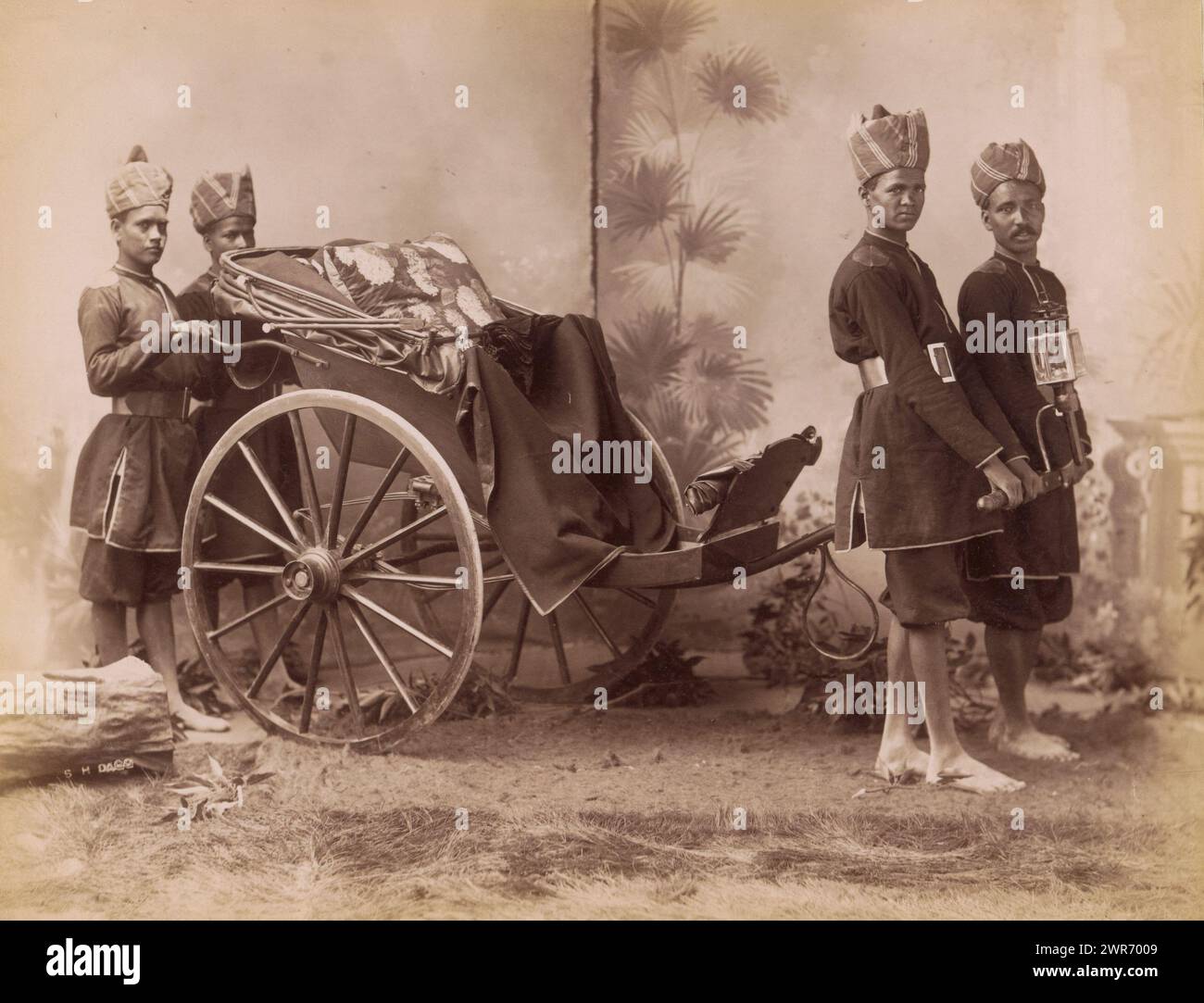 Studio portrait of four Indian men in uniform with a carriage, India, Sidney Herbert Dagg, Brits-Indië, 1890 - 1910, paper, albumen print, height 213 mm × width 275 mm, height 227 mm × width 293 mm, photograph Stock Photo