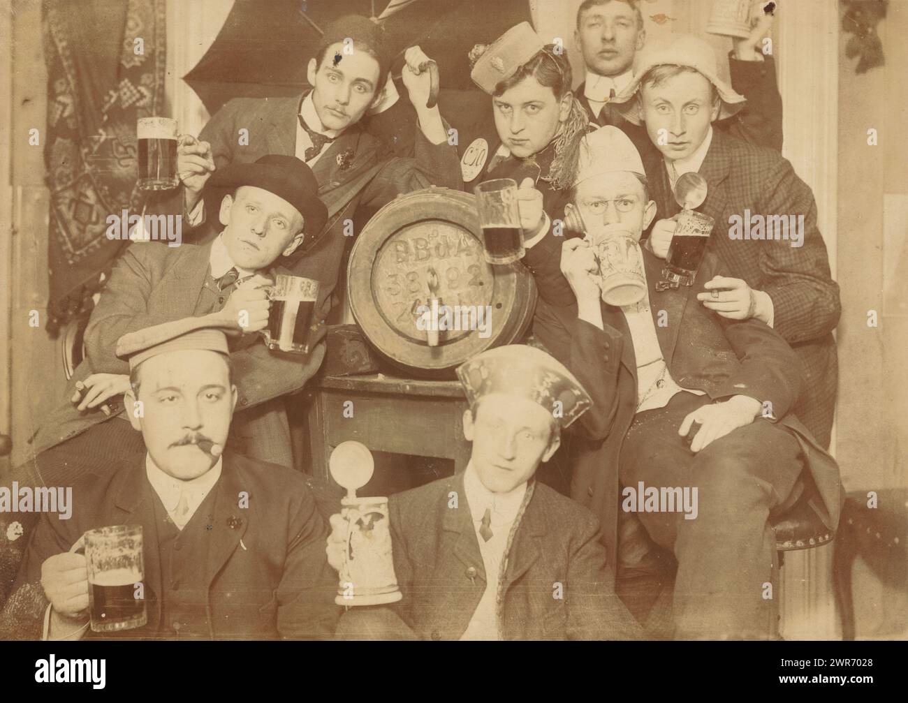 Group portrait of eight unknown young men partying and toasting, in the Scheltema hotel in Amsterdam, anonymous, Amsterdam, c. 1895 - c. 1900, baryta paper, height 139 mm × width 189 mm, photograph Stock Photo