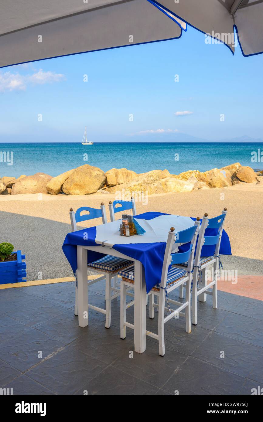 Table with chairs in Greek seaside restaurant. Kardamena village on the island of Kos, Greece Stock Photo