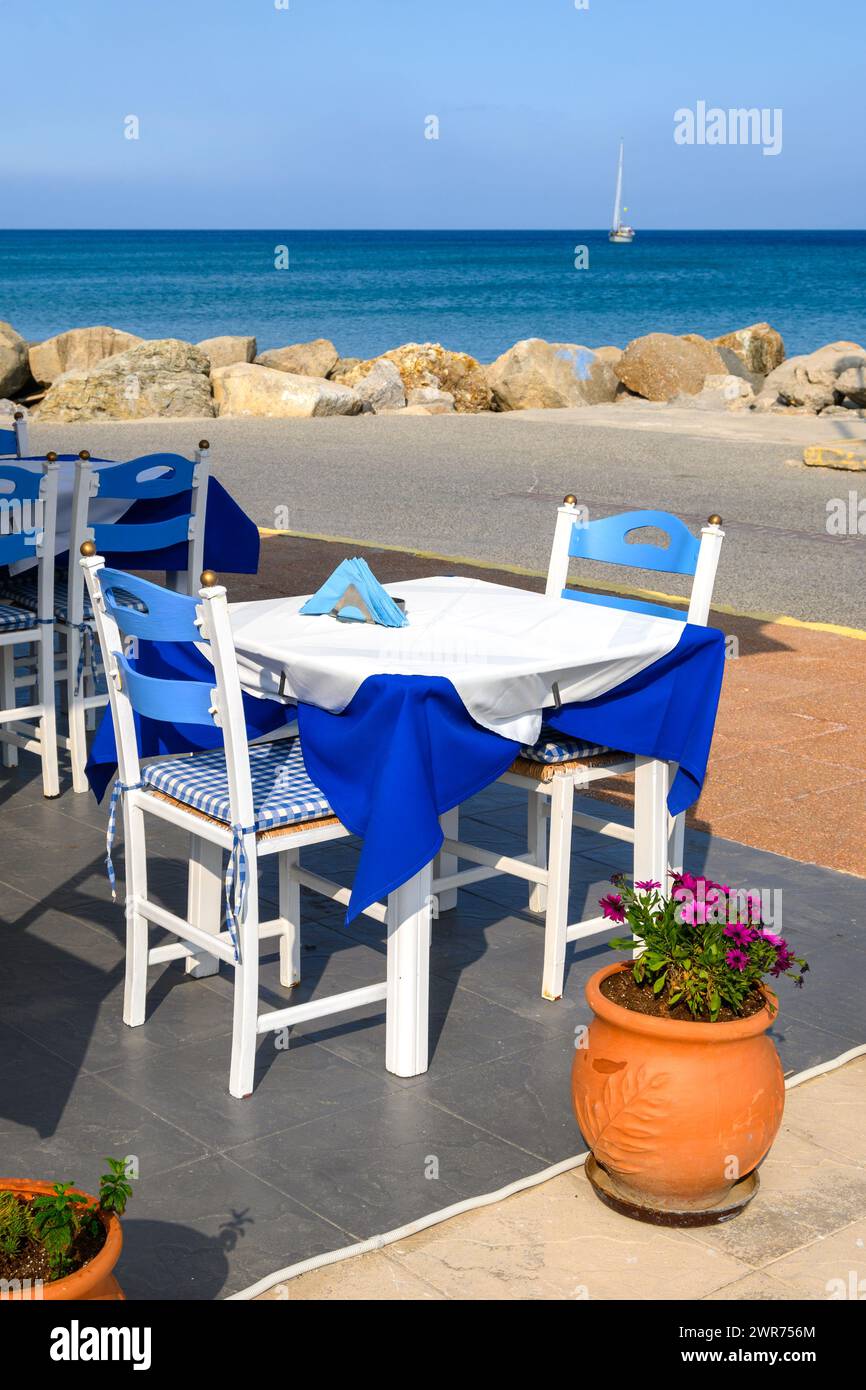 Tables with chairs in Greek seaside restaurant. Kardamena village on the island of Kos, Greece Stock Photo