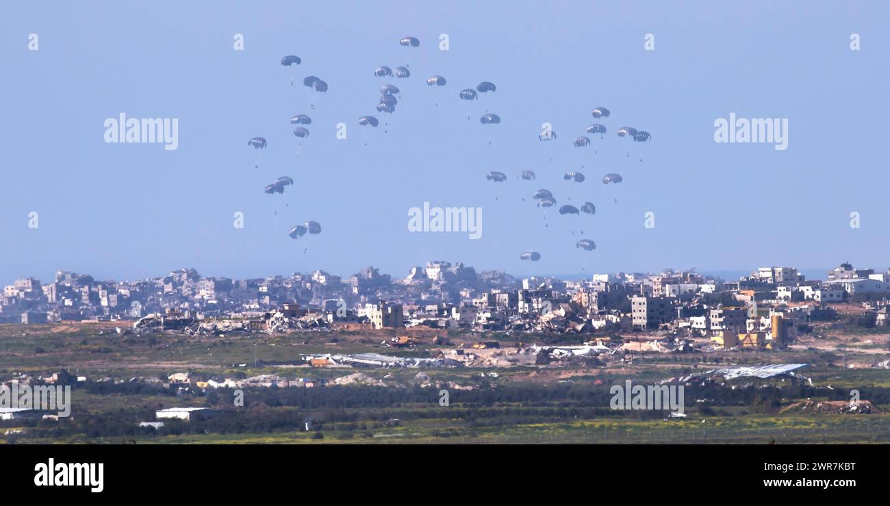 Southern Israel, Israel. 11th Mar, 2024. United States Air Force C-130 drops humanitarian aid by parachute over the central, northern Gaza Strip as seen from inside southern Israel on March 10, 2024. This photo shows three planes-full of aid as it descends to Gaza. The USA and other countries continue to drop food and other humanitarian aid supplies to Palestinians in dire need in the Gaza Strip on the first day of the month-long Moslem holiday of Ramadan. As reports continue of fighting between Israeli forces and Hamas inside Gaza. Photo by Jim Hollander/UPI Credit: UPI/Alamy Live News Stock Photo
