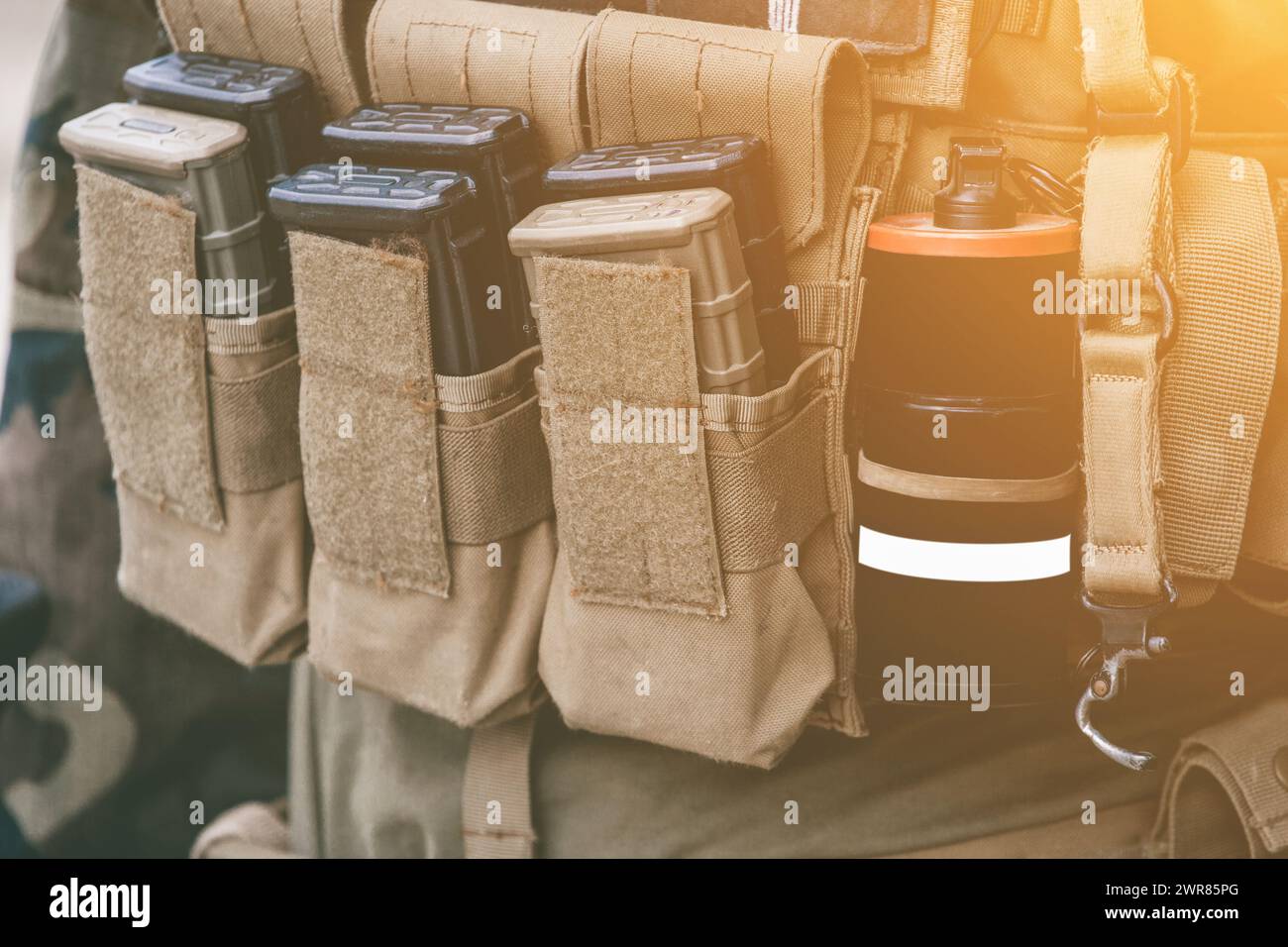 Army vest with a walkie-talkie charged collars stun grenades luminous sticks standing on a wooden box of ammunition. Stock Photo