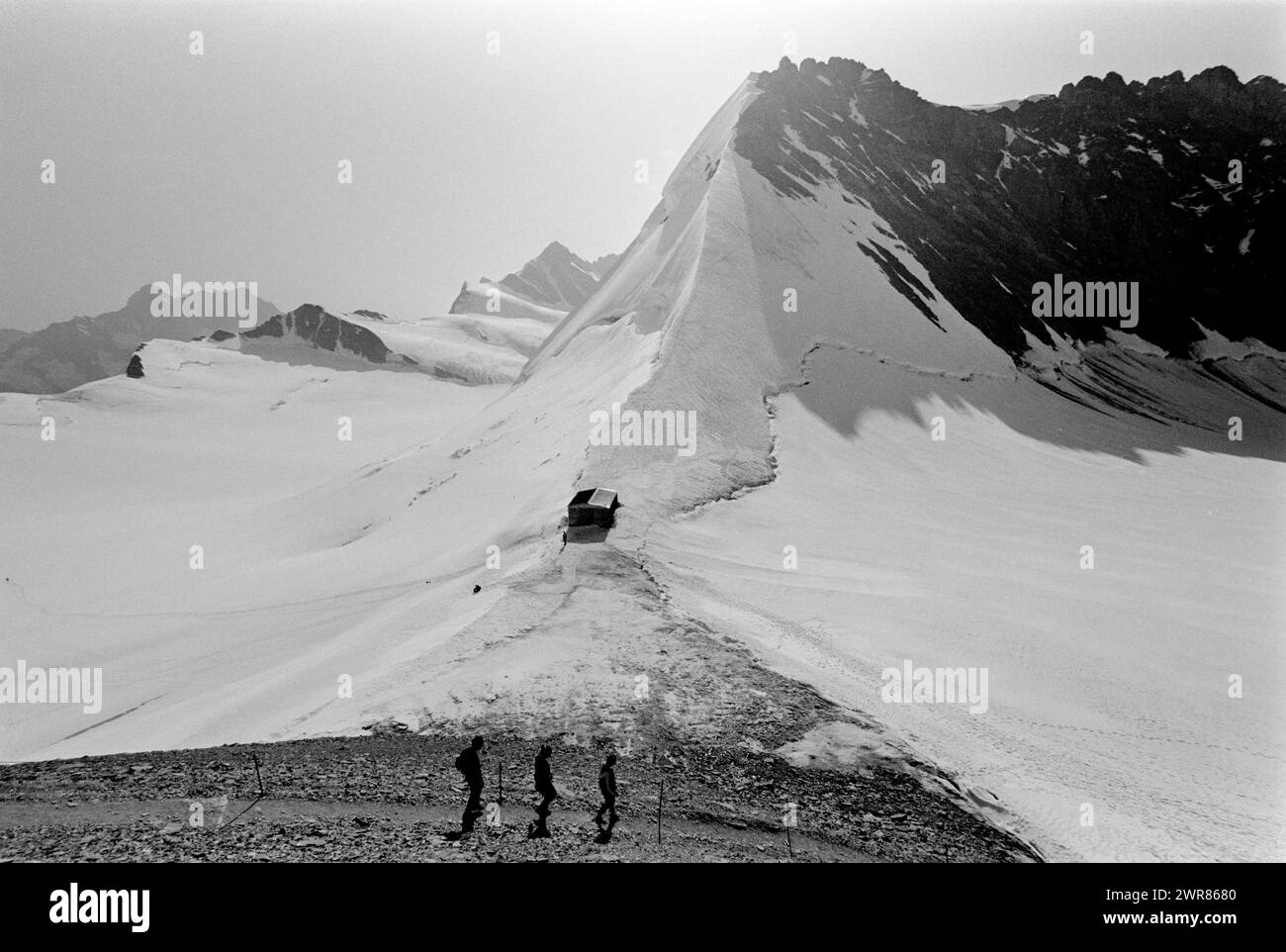 Switzerland Summit of Jungfraujoch showing walkers enjoying the Aletsch Glacier in the summer months 1991 Tourists walking to the Monchsjoch Hut above the Aletsch Glacier. in the area known as the Top of Europe. This scan made in 2024 Stock Photo