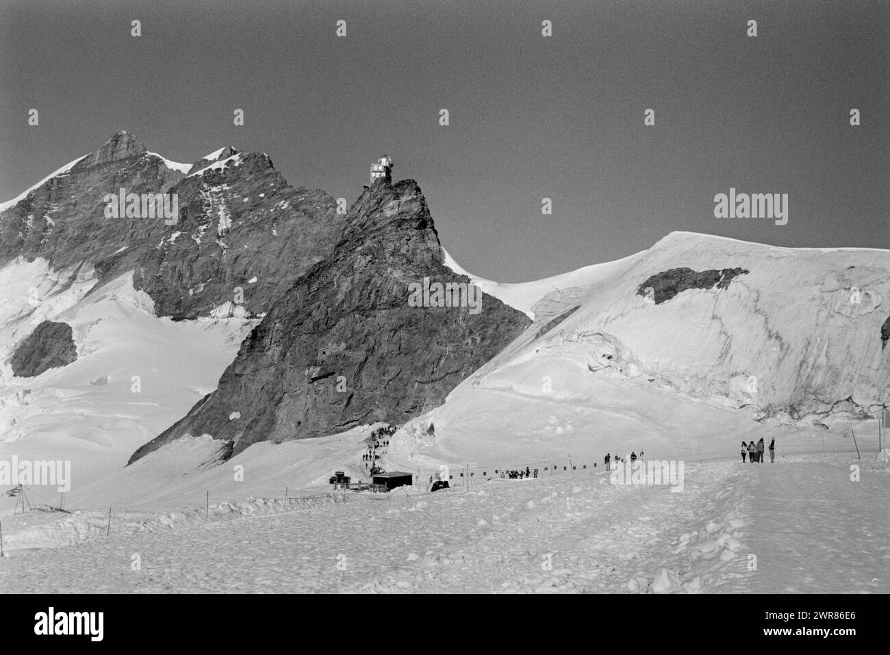Switzerland Summit of Jungfraujoch showing walkers enjoying the Aletsch Glacier in the summer months 1991 Tourists walking to the Monchsjoch Hut above the Aletsch Glacier. in the area known as the Top of Europe. This scan made in 2024 Stock Photo