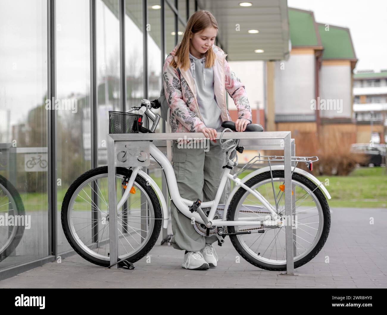 Girl Fastens Bike Near Supermarket Bike Parking In Spring Stock Photo