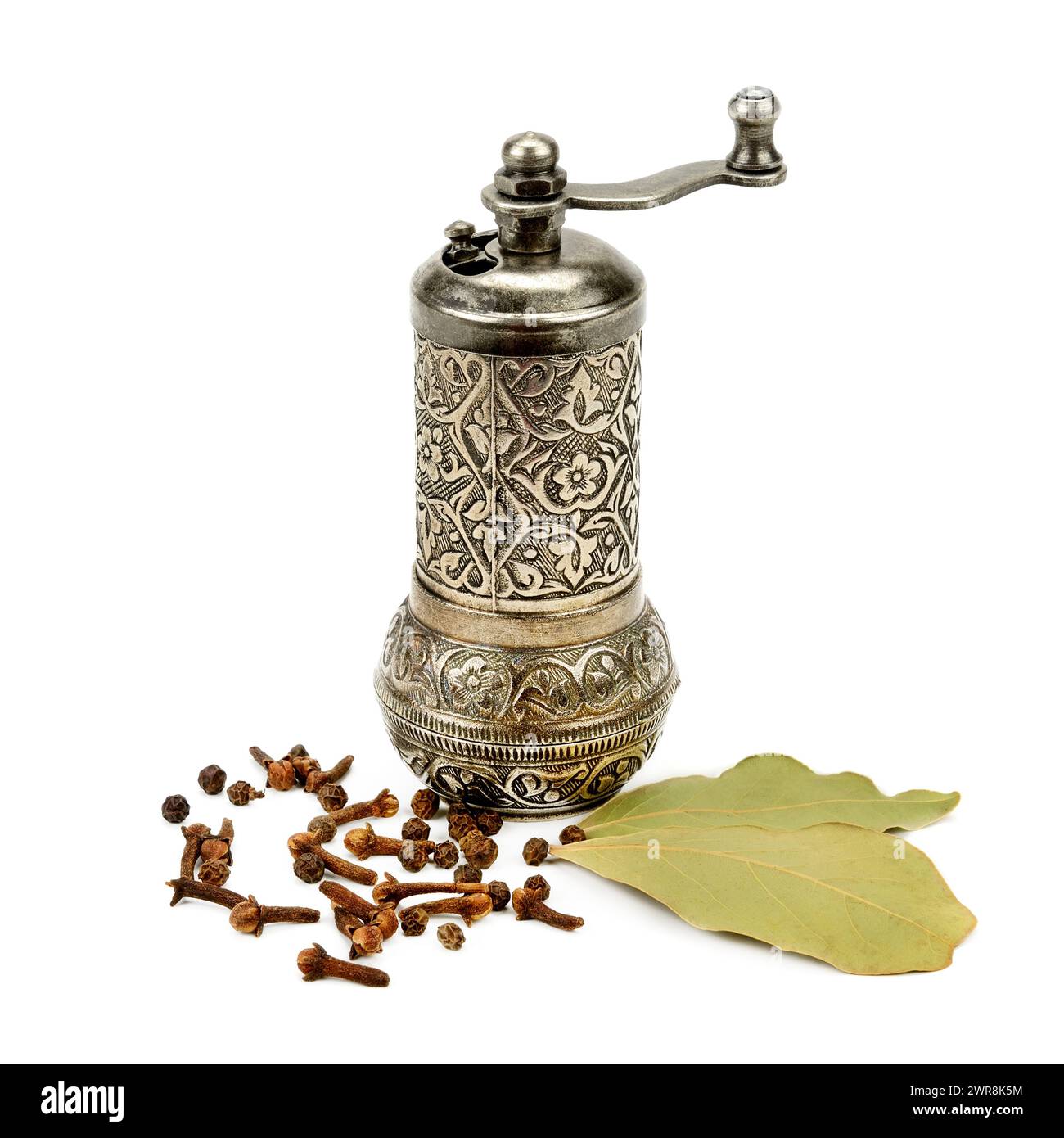 Manual grinder, clove spice and laurel isolated on white background