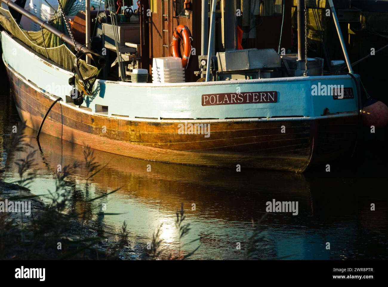 A ship with buoys floating near another boat on the water Stock Photo