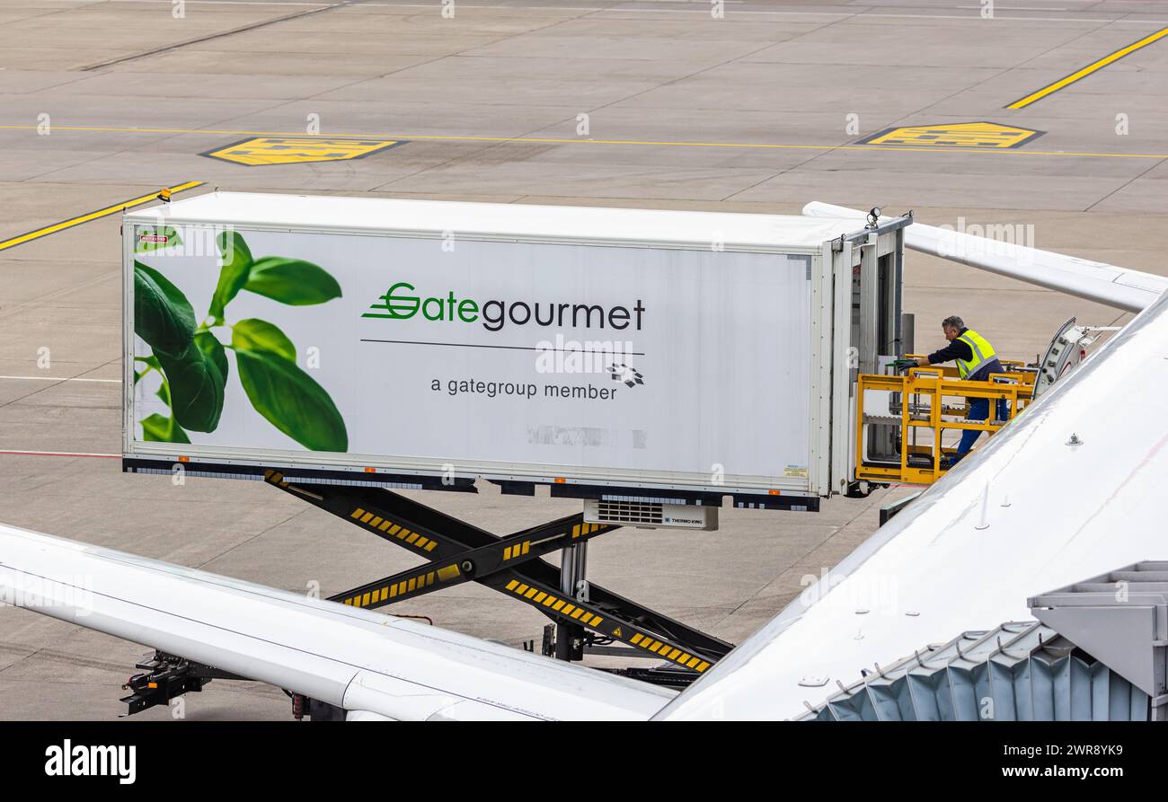 Ein Mann des Airlinezulieferers Gategourmet schafft Container in ein Flugzeug. Gategourmet ist für die Verpflegung auf den Flügen verantwortlich. (Zür Stock Photo
