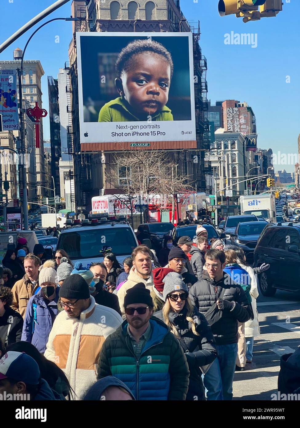 Crowds of people walk along Canal Street on Chinese New Year with a prominant Apple Iphone billboard in the background. Stock Photo