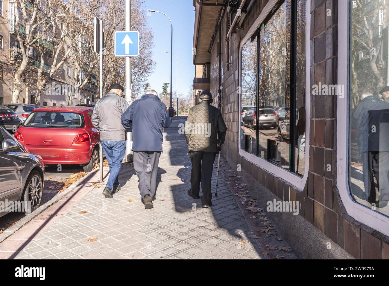 A group of older people walking on a sidewalk in the city Stock Photo