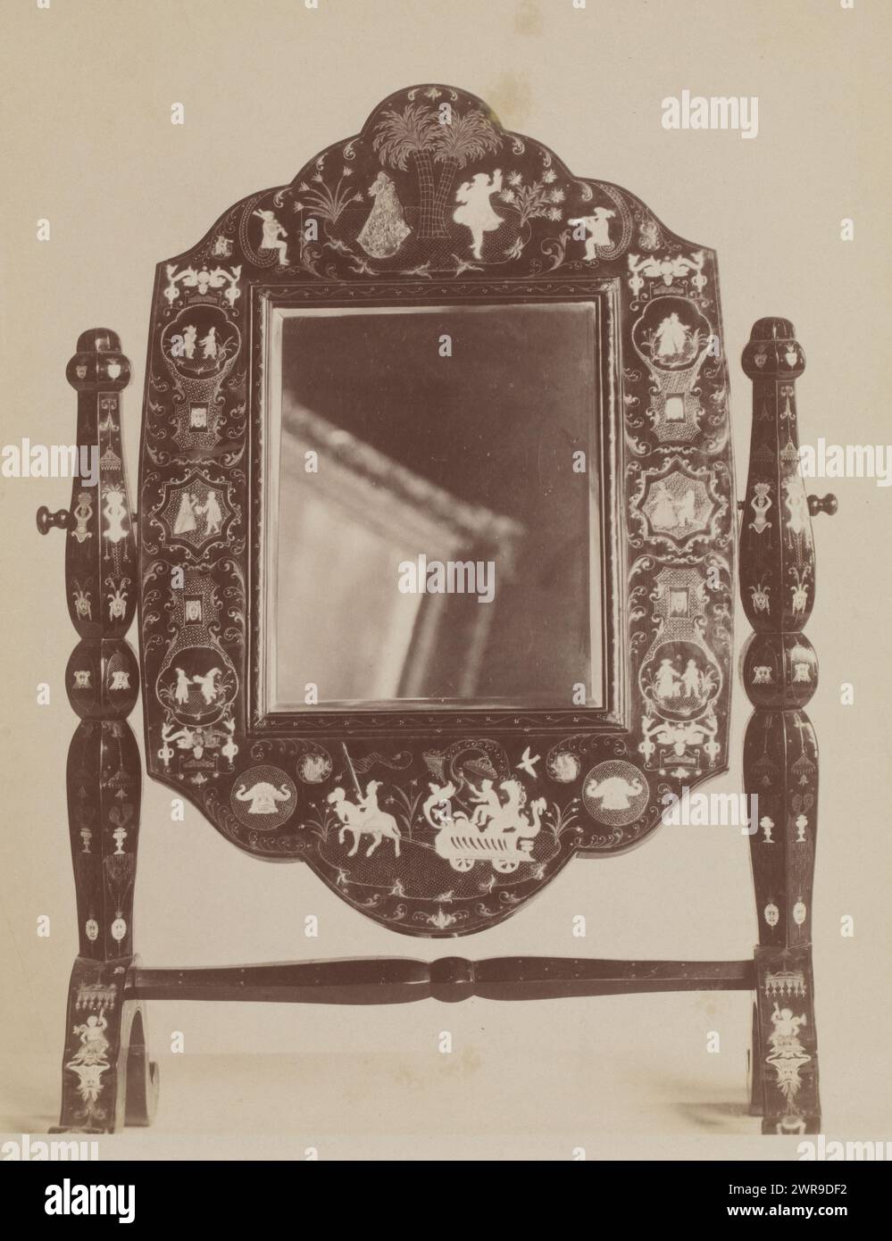 Shot of a mirror with a picture frame reflected in it. Shot of a richly decorated table mirror (18th century French) made of lacquer, beautifully inlaid with possibly ivory edge decorations. A picture frame is visible in the mirror. Comes from a furniture factory in rue Faubourg St. Antoine, the 19th century artists' district in Paris., anonymous, France, c. 1900, photographic support, albumen print, height 201 mm × width 162 mm × height 212 mm × width 172 mm, photograph Stock Photo