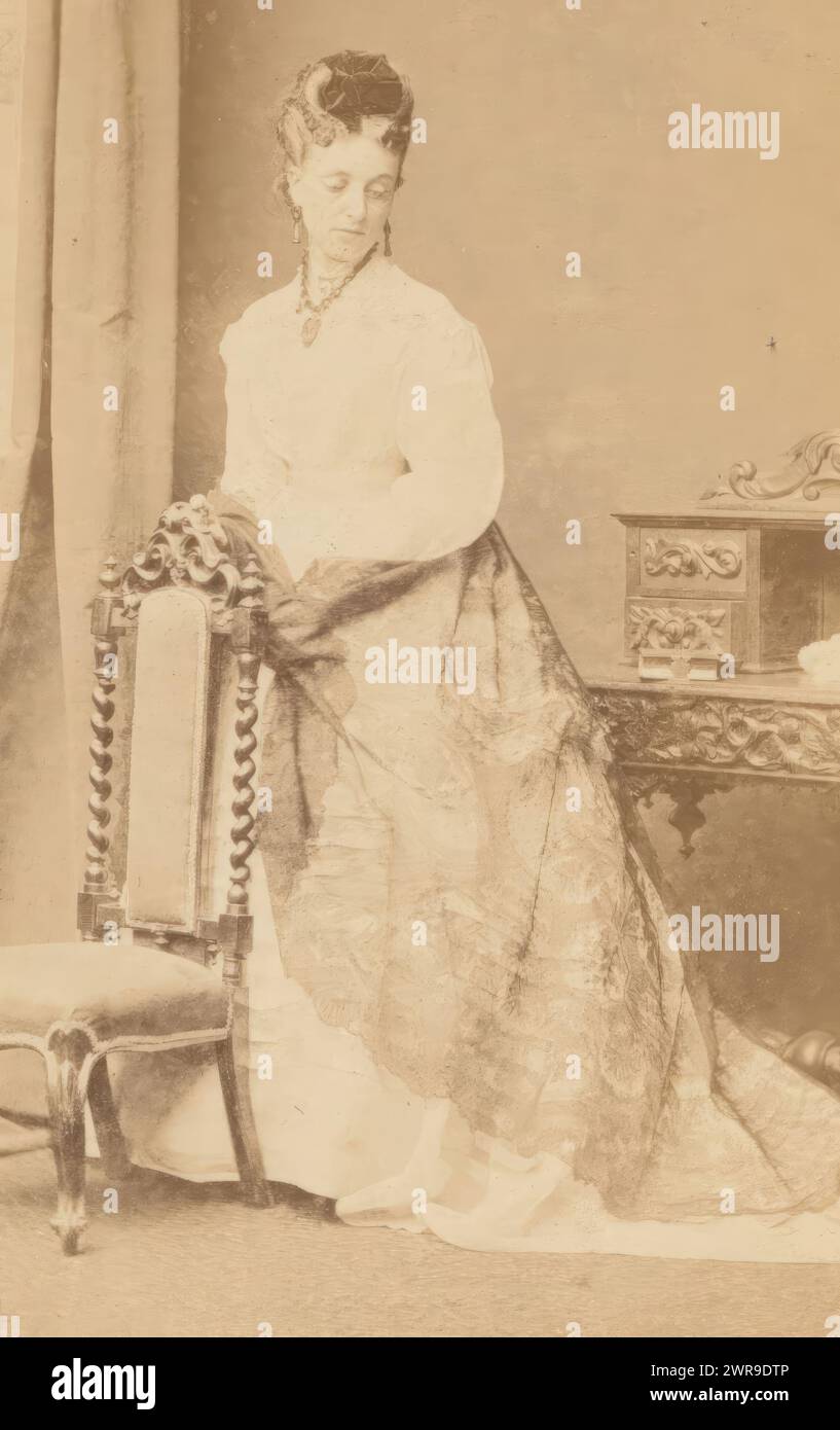 Portrait of a woman in a white dress near a chair and desk, This photo is part of an album., Johnstone & O'Shannessy & Co., Henry James Johnstone, O'Shannessy, Melbourne, 1865 - 1875, cardboard, albumen print, height 85 mm × width 51 mm, photograph Stock Photo