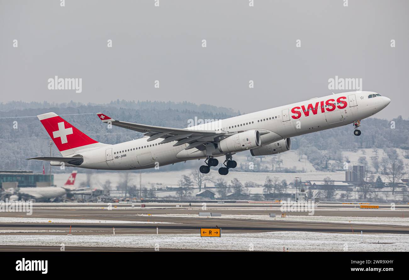 Ein Airbus A340-313X von Swiss International Airlines startet von Startbahn 16 des sich in winterlicher Landschaft befindlichen Flughafen Zürich. Regi Stock Photo