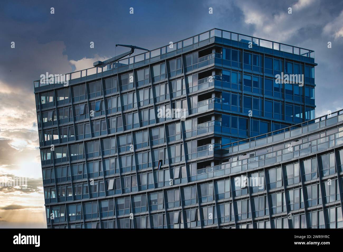 Modern office building facade against a dramatic sunset sky in ...