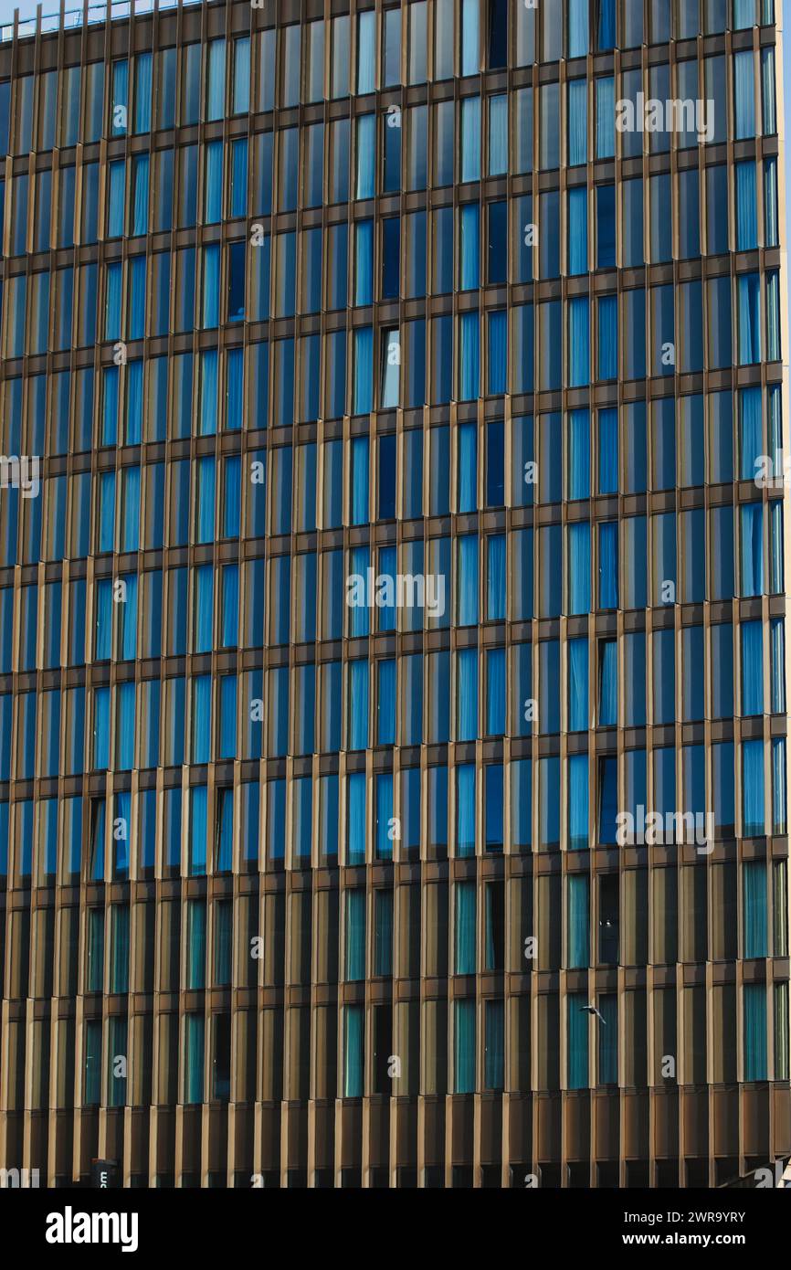 Modern office building facade with blue glass windows and steel ...