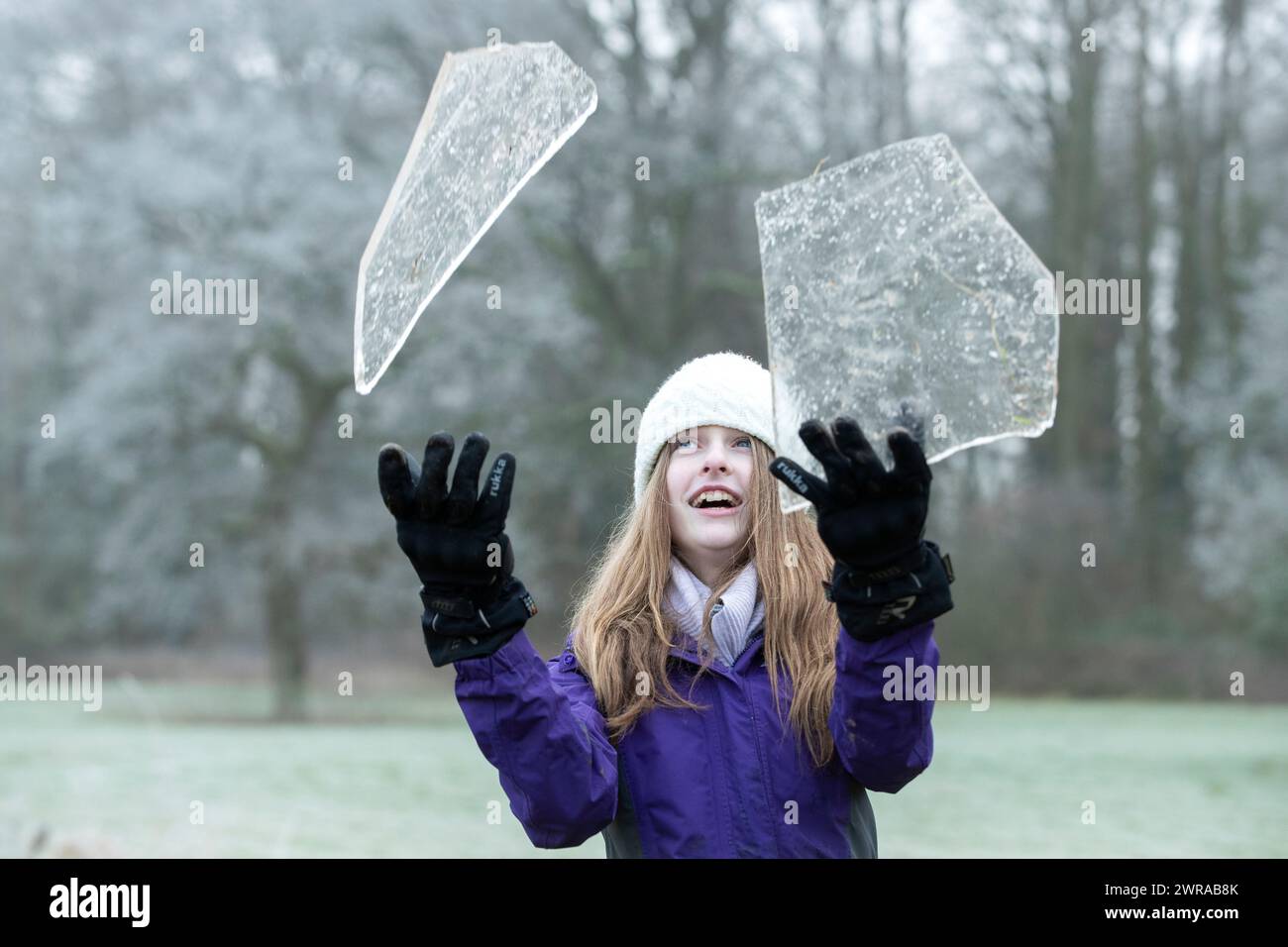 07/01/21   After overnight temperatures plunged well below zero, Freya Kirkpatrick (13), uses her head to smash chunks of ice, collected from frozen p Stock Photo