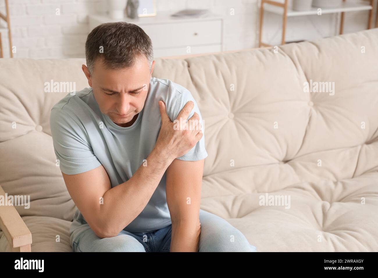 Mature man suffering from shoulder pain at home Stock Photo - Alamy