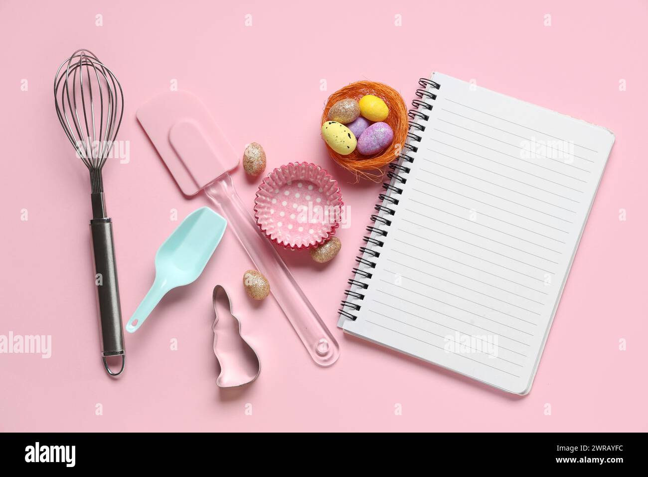 Blank notepad for recipes with Easter eggs and baking tools on pink background Stock Photo