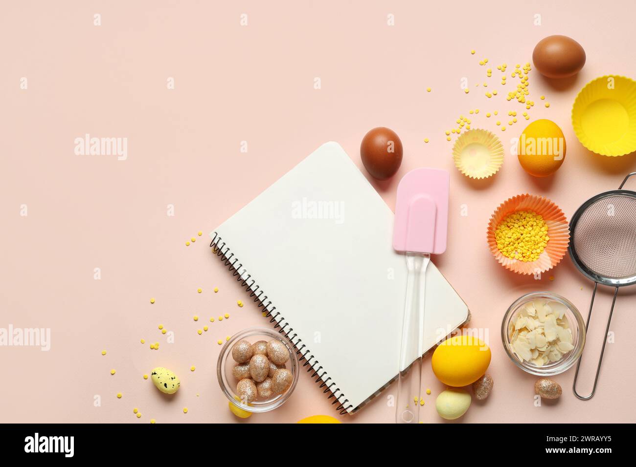 Blank notepad for recipes with Easter eggs and kitchen tools on beige background Stock Photo