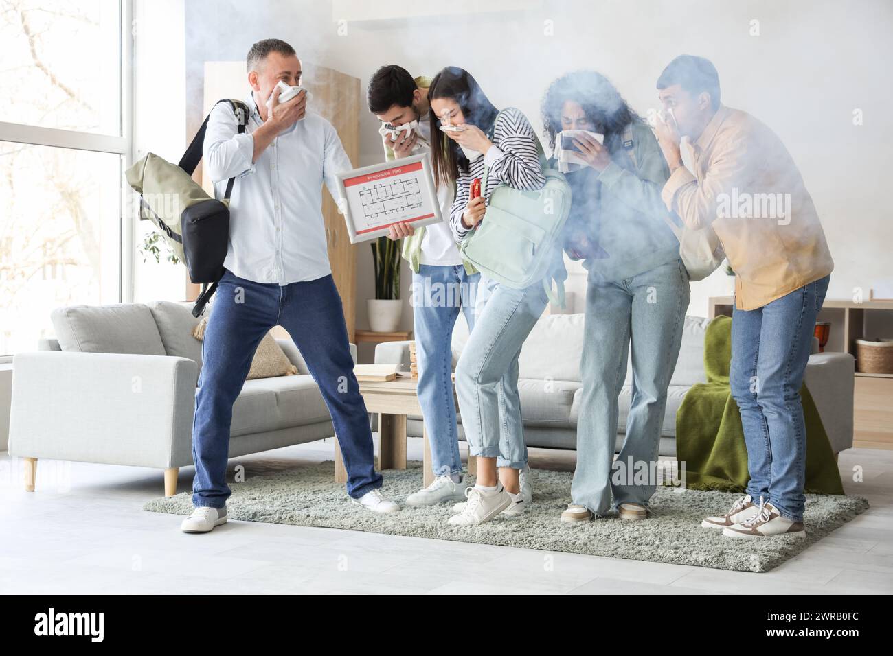 People with evacuation plan choking on smoke in burning building Stock Photo