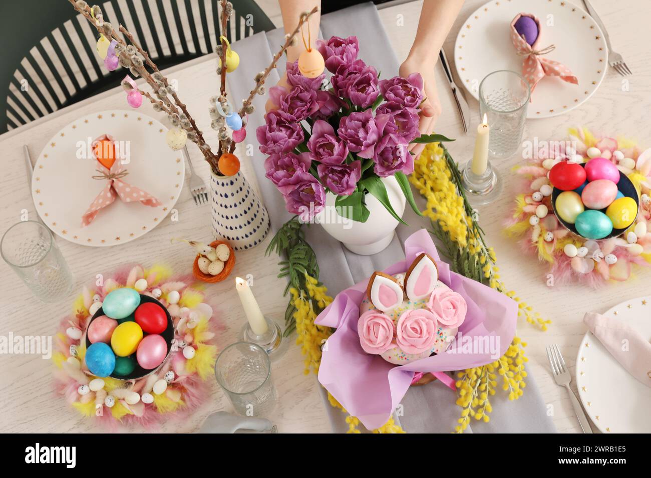 Beautiful Easter table setting with spring flowers, Easter cake and painted eggs Stock Photo