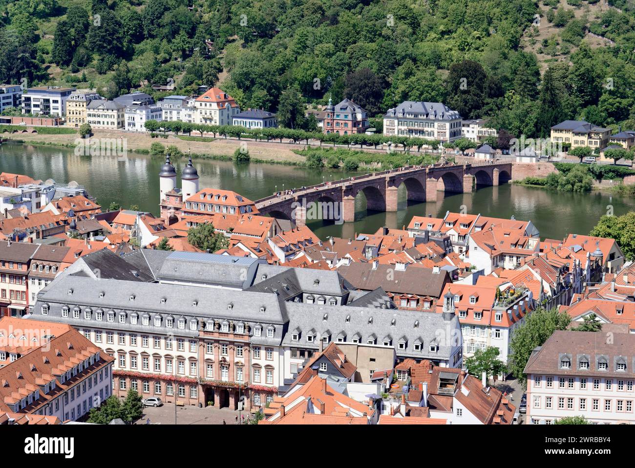 Historic stone bridge over a river (Neckar), with neighbouring riverside houses, Heidelberg, Baden-Wuerttemberg, Germany Stock Photo