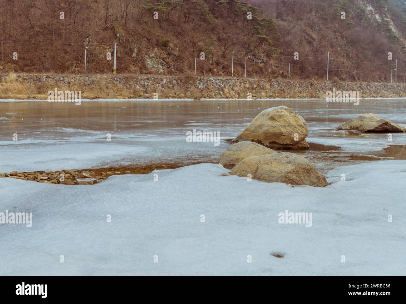 Peaceful frozen river scene with rocks during a calm winter dusk, in ...