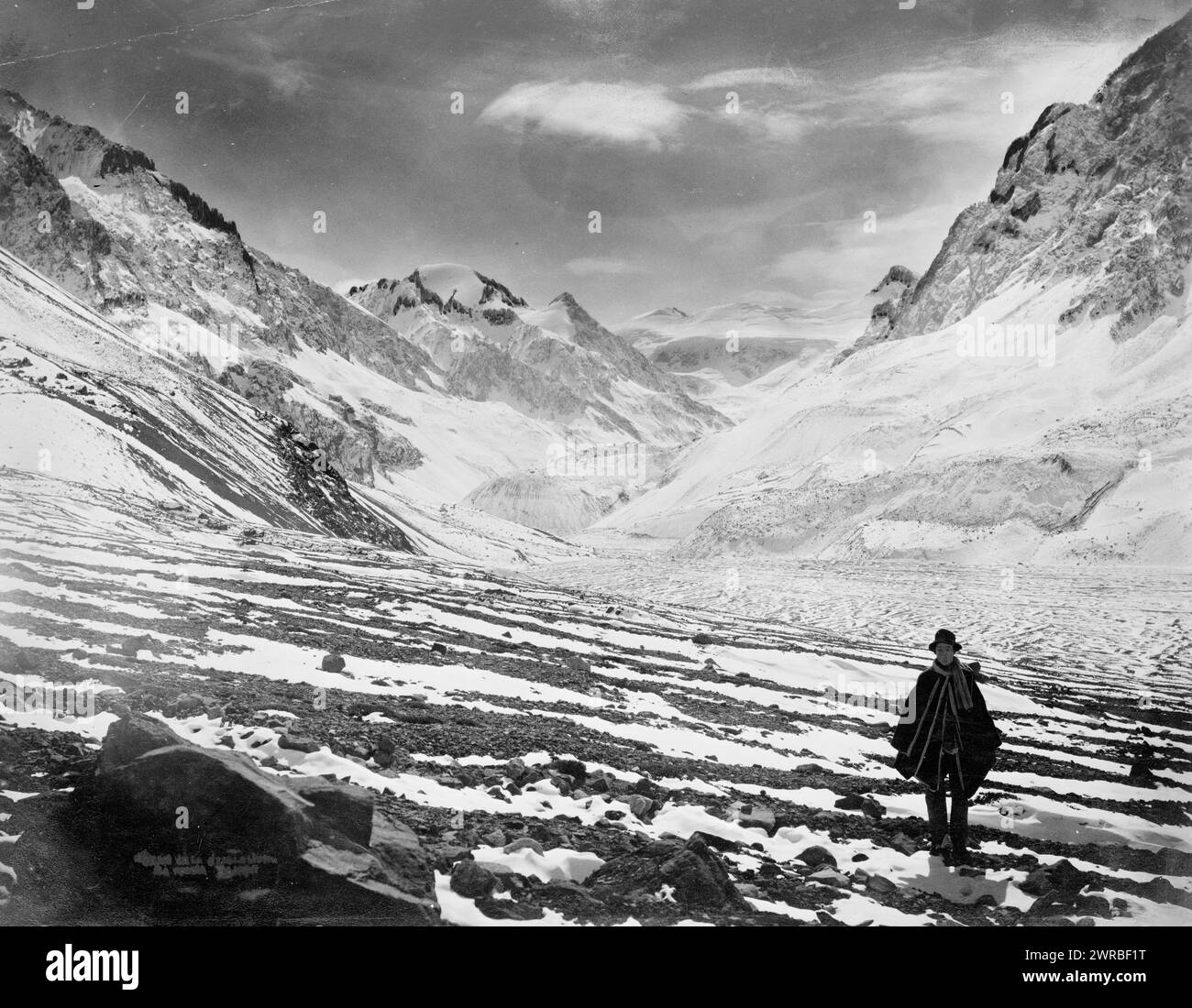 Chile - Aconcagua Valley, Photo shows a man standing in snowfields in the Aconcagua River Valley between mountains in Chile., Carpenter, Frank G. (Frank George), 1855-1924, collector, between 1890 and 1930, Valleys, Chile, Aconcagua River Valley, 1890-1930, Photographic prints, 1890-1930., Photographic prints, 1890-1930, 1 photographic print Stock Photo