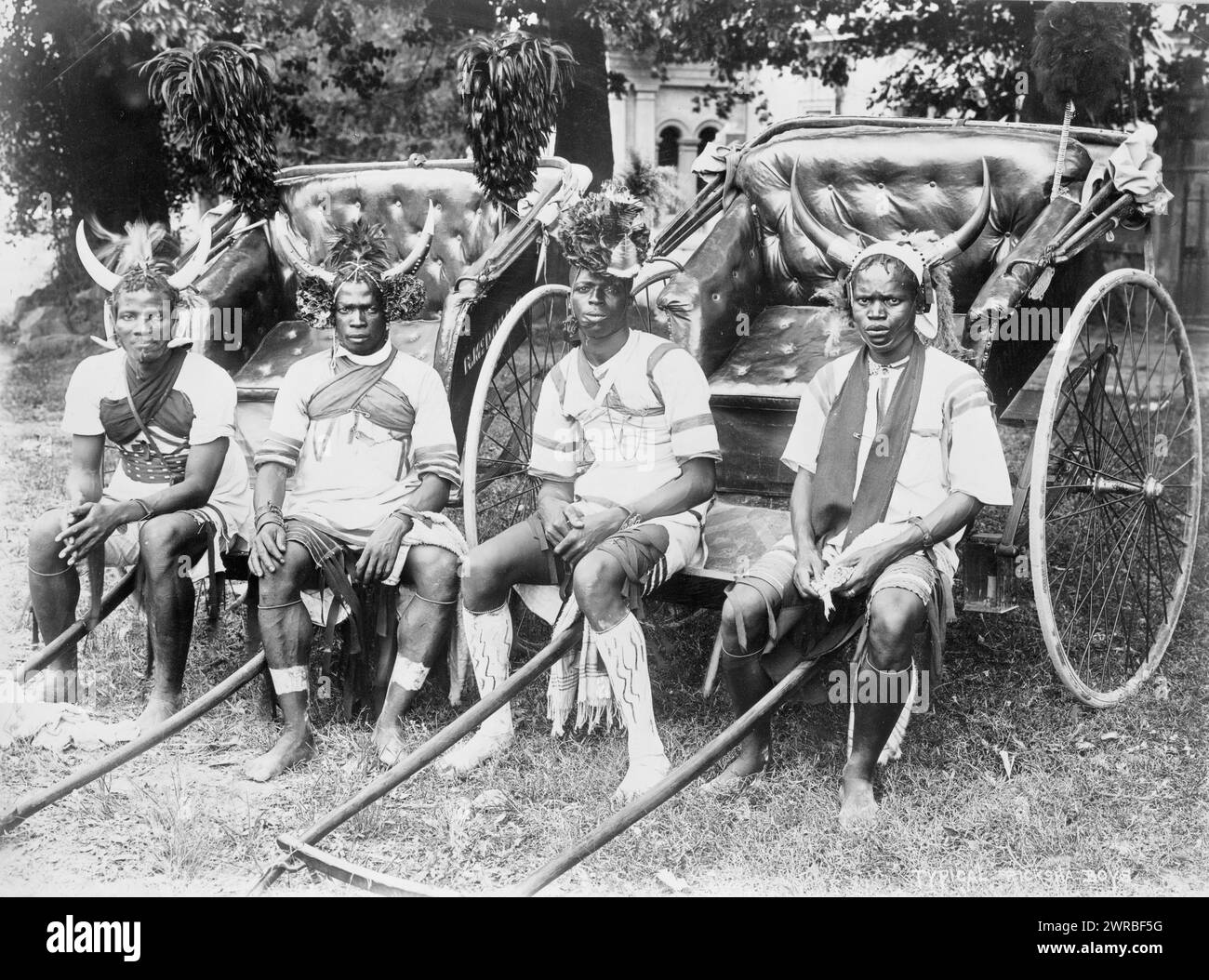Ricksha boys, Durban, South Africa, Photo shows four young men sitting at the front of rickshaws, facing front, three are wearing horned headdresses and the fourth is wearing a floral headdress., Carpenter, Frank G. (Frank George), 1855-1924, collector, between 1890 and 1923, Rickshaws, South Africa, Durban, 1890-1930, Group portraits, 1890-1930., Portrait photographs, 1890-1930, Group portraits, 1890-1930, 1 photographic print Stock Photo