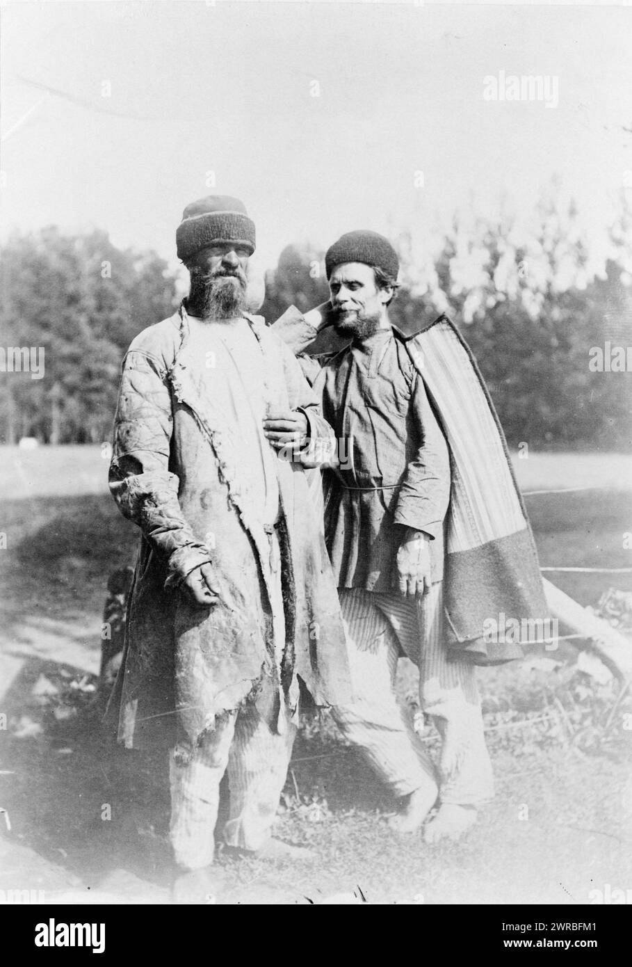 Two men standing, outdoors, full-length, Russia, between ca. 1880 and 1924, Prisoners, Russia, 1880-1930, Photographic prints, 1880-1930., Portrait photographs, 1880-1930, Photographic prints, 1880-1930, 1 photographic print Stock Photo