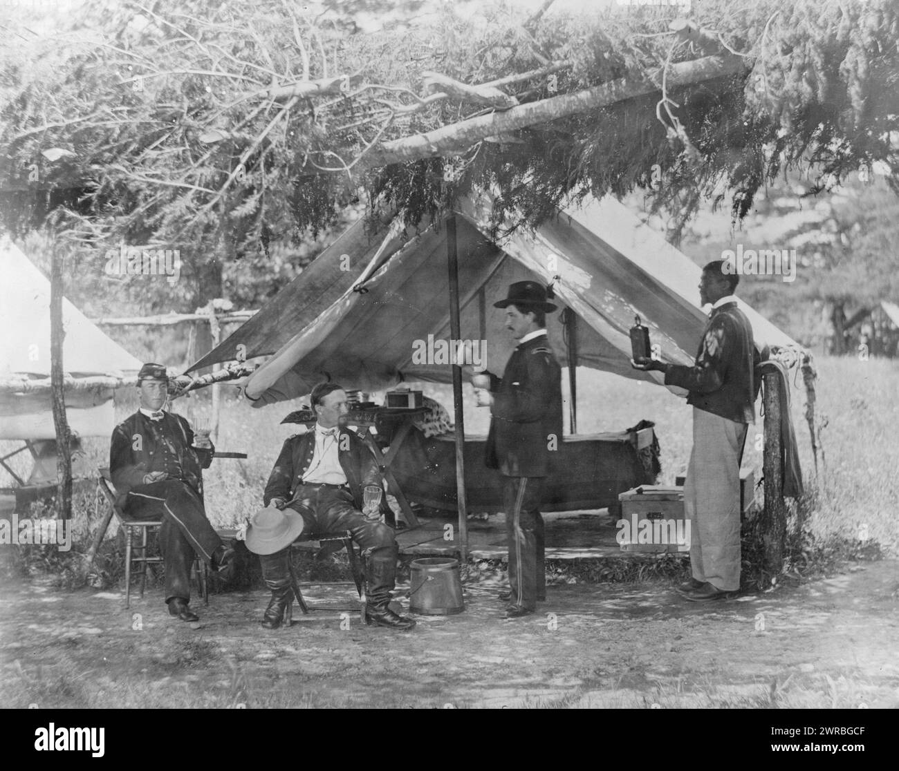 Maj. H.H. Humphrey and others, Three Civil War Union soldiers, drinking outside a canopied living quarters area, African American on right holding bottle., Smith, William Morris, photographer, 1865 June., Humphrey, H. H., Military service, Group portraits, 1860-1870., Portrait photographs, 1860-1870, Group portraits, 1860-1870, 1 photographic print Stock Photo