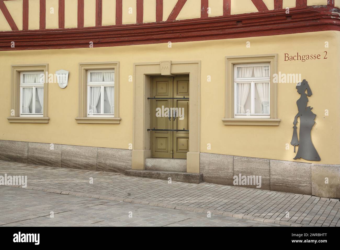 Historic painter's corner house built in 1774 and museum, female figure, lady, silhouette, alleyway name, front door, window, house number, 2, yellow Stock Photo