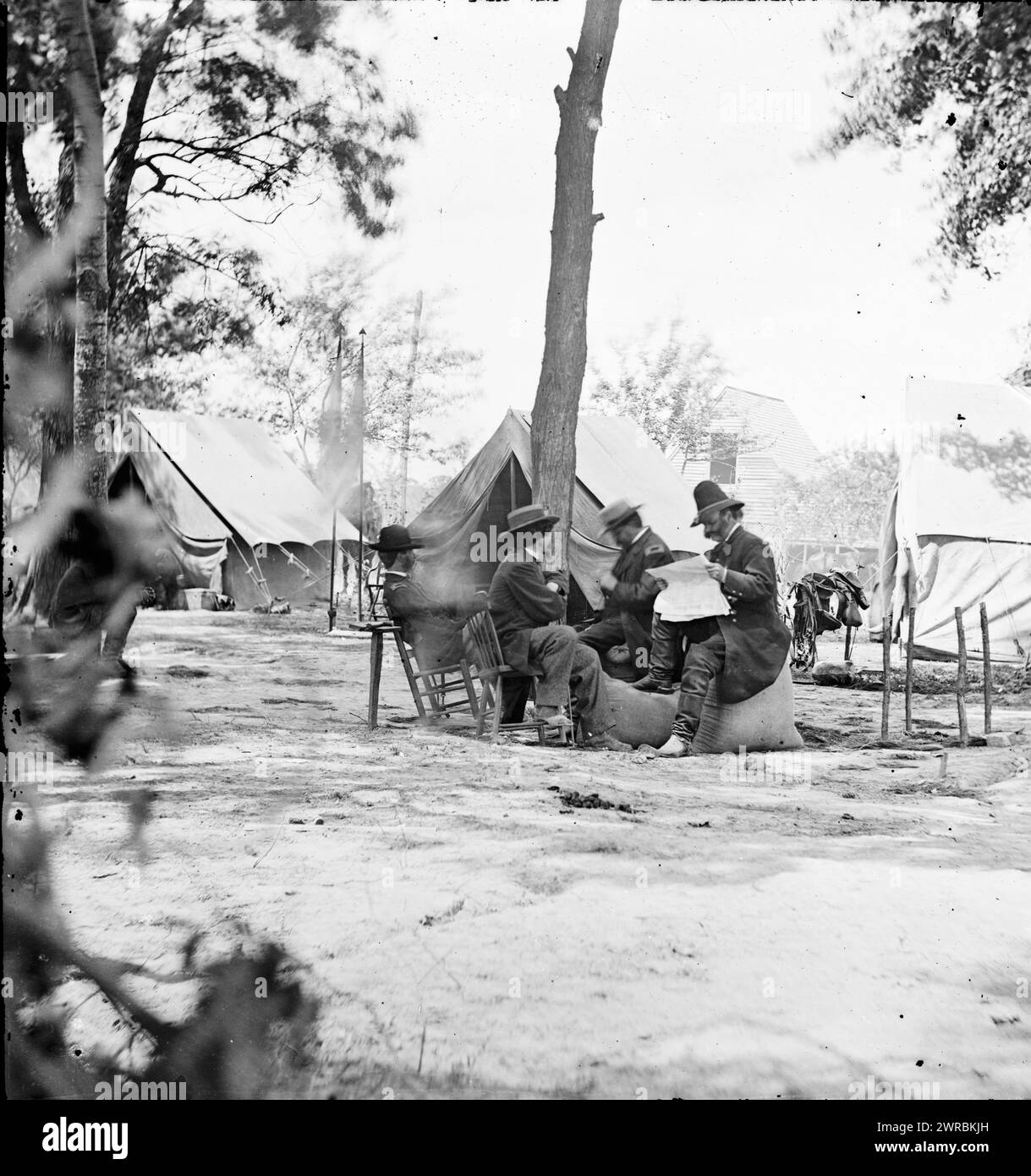 Gen. Ambrose E. Burnside (reading newspaper) with Mathew B. Brady (nearest tree) at Army of the Potomac headquarters, Photograph from the main eastern theater of the war, Burnside and Hooker, November 1862-April 1863., 1864 June 11 or 12, United States, History, Civil War, 1861-1865, Stereographs, 1860-1870., Stereographs, 1860-1870, Wet collodion negatives, 1 negative (2 plates): glass, stereograph, wet collodion Stock Photo