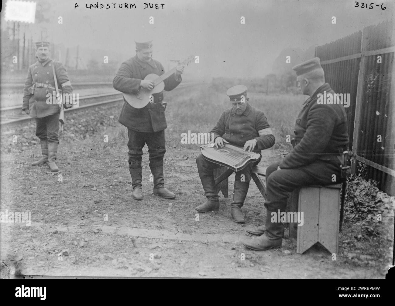 A Landsturm Duet, Photograph shows men playing stringed instruments by the railroad tracks during World War I., 1914, World War, 1914-1918, Glass negatives, 1 negative: glass Stock Photo