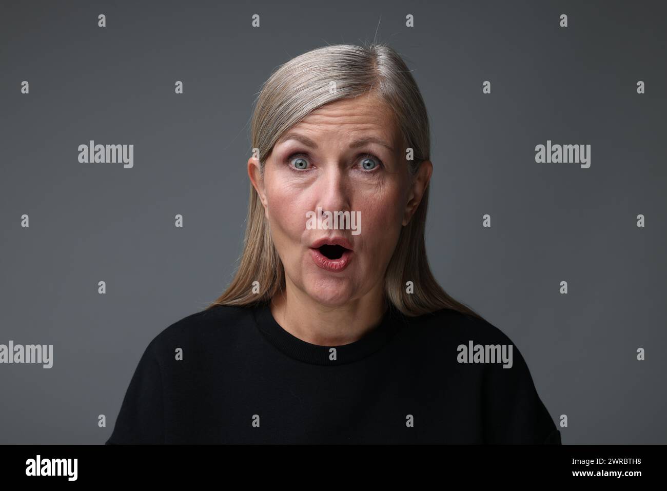 Personality concept. Portrait of emotional woman on gray background Stock Photo