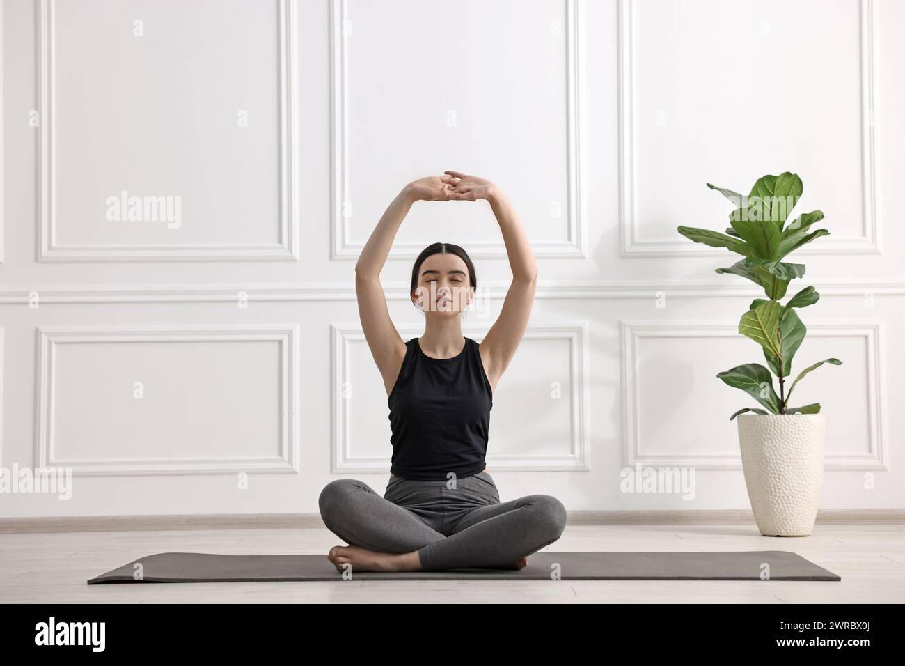 Beautiful girl meditating on mat in yoga studio Stock Photo - Alamy
