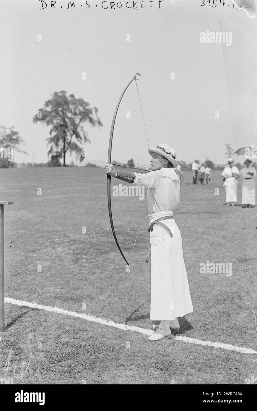 Dr. M.S. Crockett bow & arrow, Photograph shows Dr. Marguerite S. Crockett competing at the National Archery Tournament, Jersey City, New Jersey, August 22-25, 1916., between ca. 1915 and ca. 1920, Glass negatives, 1 negative: glass Stock Photo