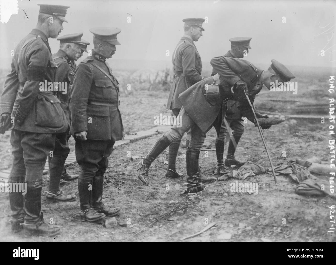 King Albert on Battle Field, Photograph shows an aide-de-camp of King Albert I of Belgium picking up a souvenir on the Somme battlefield near Pozieres, France, May 16, 1917. King Albert I and General Hubert Gough, the British Commander of the Fifth Army stand in background., 1917 May 16, World War, 1914-1918, Glass negatives, 1 negative: glass Stock Photo
