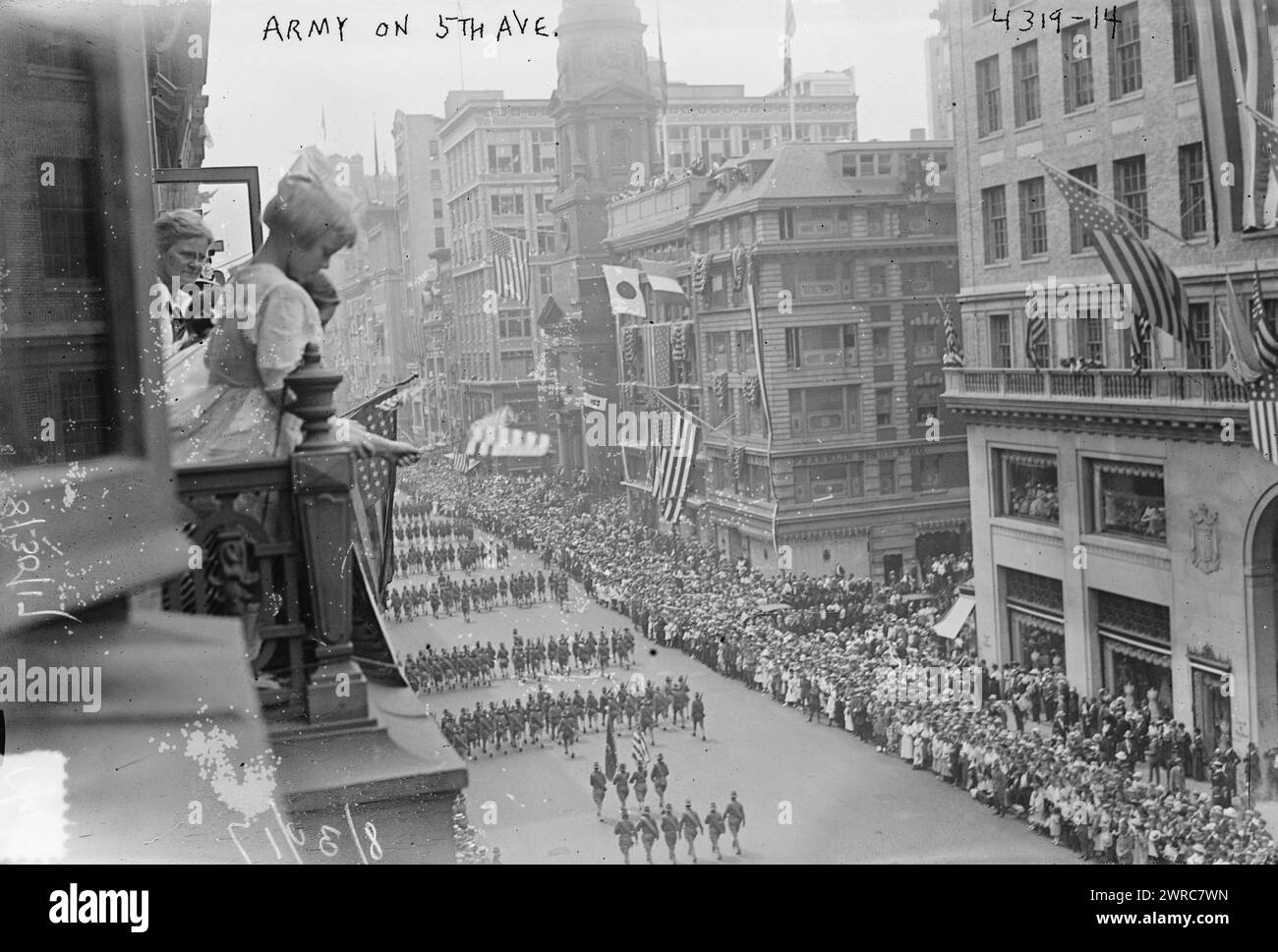 Army on 5th Ave., Photograph shows girls on a balcony and crowds on sidewalk watching a parade of the 27th Division (National Guard of New York) on August 30, 1917 in New York City. The view is looking south toward the intersection of East 38th Street. On the far side of 38th is the Franklin Simon store, and on the near side is Lord & Taylor at 424-34 5th Avenue., 1917 Aug. 30, World War, 1914-1918, Glass negatives, 1 negative: glass Stock Photo