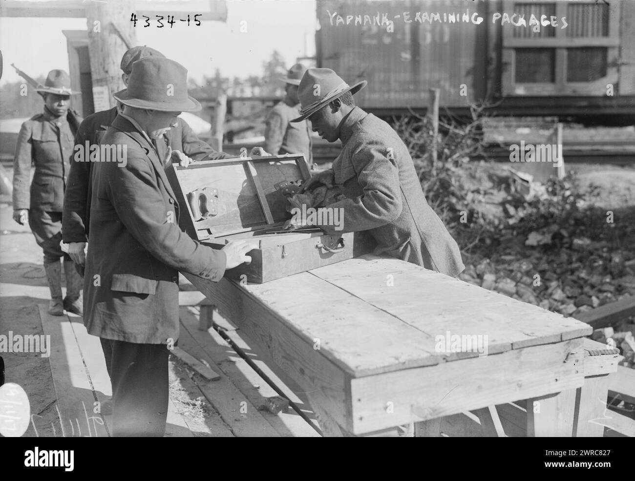 Yaphank, examining packages, Photograph shows African American soldier examining a package at Camp Upton, a U.S. Army installation located on Long Island, in Yaphank, New York, during World War I., 1917 September 11, World War, 1914-1918, Glass negatives, 1 negative: glass Stock Photo