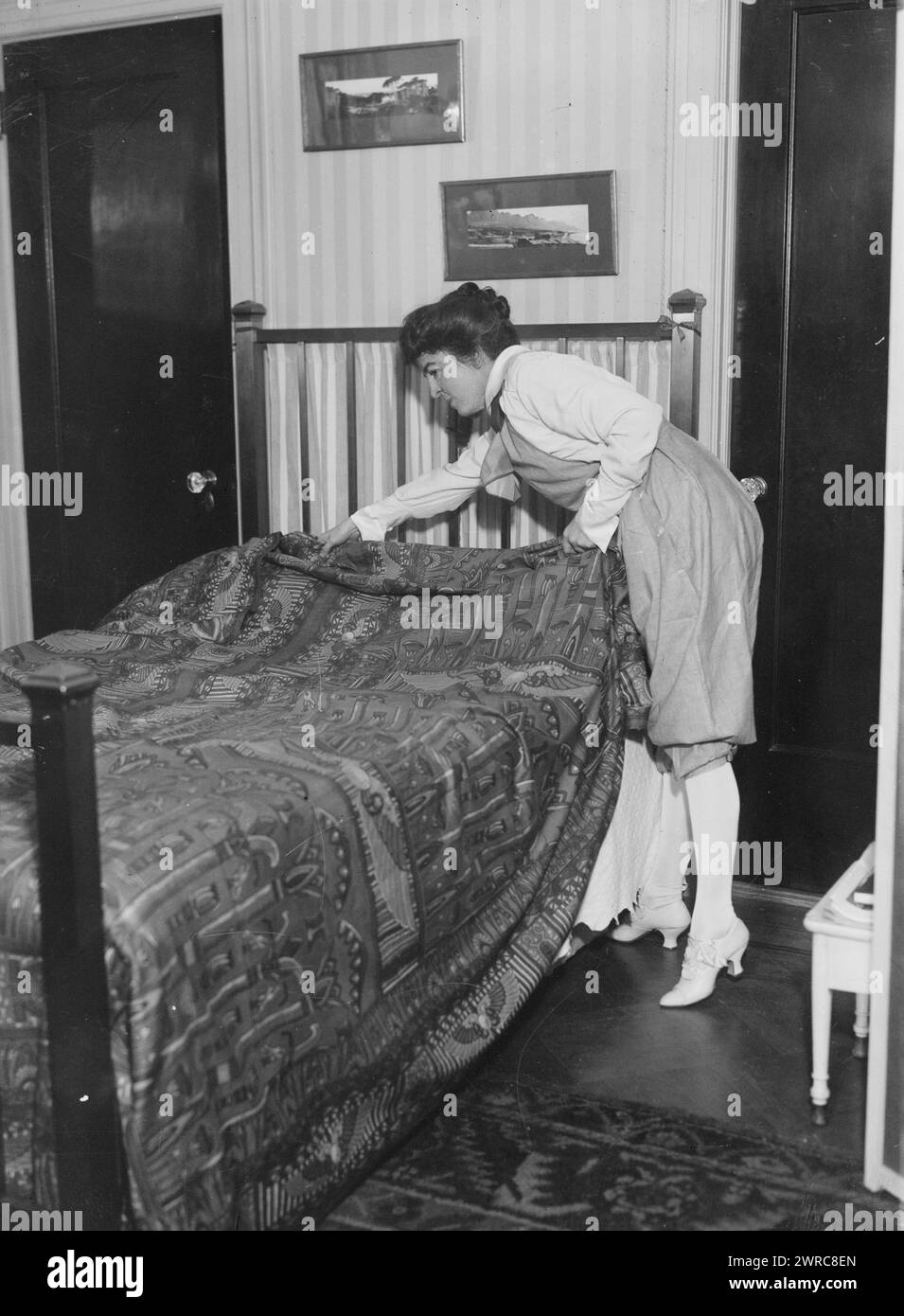 Maude i.e. Maud Powell, Photo shows American violinist Maud Powell (1867-1920) making a bed., between ca. 1915 and ca. 1920, Glass negatives, 1 negative: glass Stock Photo
