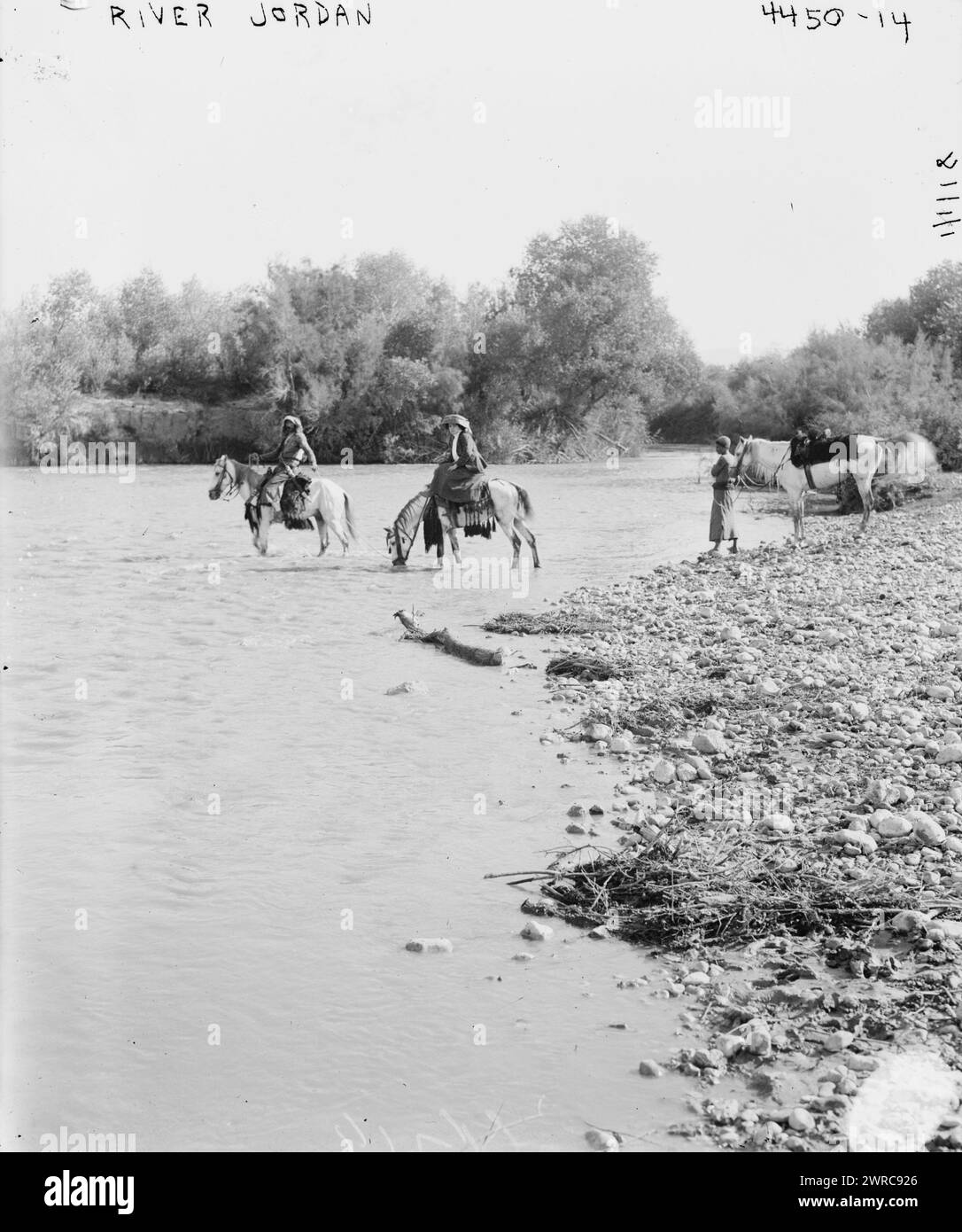 River Jordan, Photograph shows a man, boy and woman on horseback crossing the Jordan River., 1918 Jan. 1, Glass negatives, 1 negative: glass Stock Photo